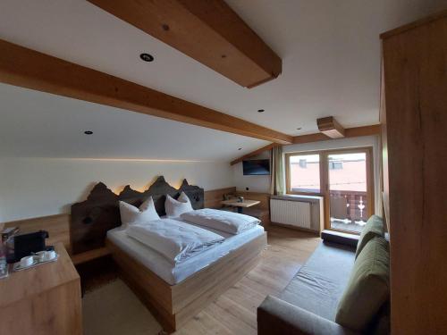 a bedroom with a bed and a couch in it at Forellenstube in Lofer