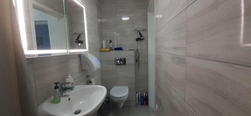 een witte badkamer met een wastafel en een toilet bij Apartman for You in Gyenesdiás