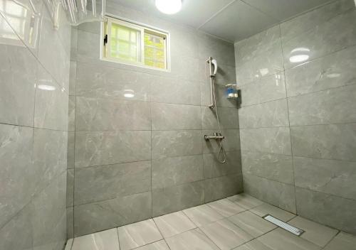 a bathroom with a shower with a glass door at 玉蟾園民宿 寵物友善 YuChanYuan B&B in Chishang