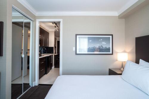 a hotel room with a bed and a bathroom at Sandman Hotel Oakville in Oakville
