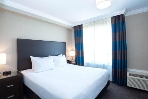 a hotel room with a bed and a window at Sandman Hotel Oakville in Oakville
