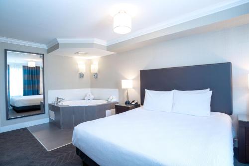 a hotel room with a bed and a bath tub at Sandman Hotel Oakville in Oakville