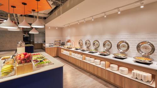 a buffet line in a restaurant with food on display at Holiday Inn Express Taichung Park by IHG in Taichung