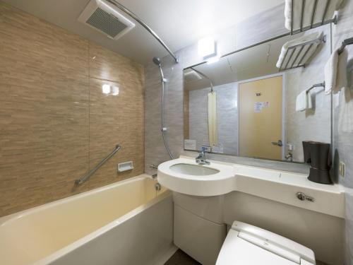La salle de bains est pourvue d'un lavabo, d'une baignoire et de toilettes. dans l'établissement Hotel Villa Fontaine Tokyo-Ueno Okachimachi, à Tokyo
