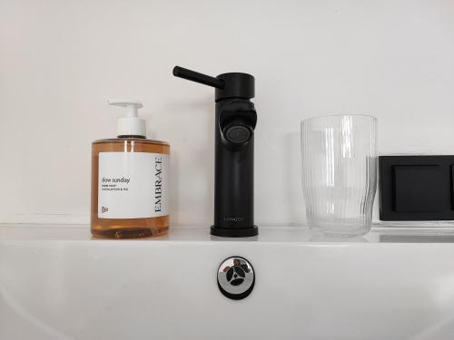a counter with a bottle of soap and a glass at Guesthouse at the Amstel river with 2BR 2BA and garden in Amstelveen