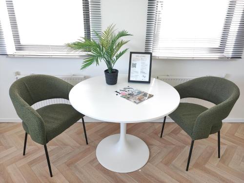 une table blanche avec quatre chaises et une plante sur elle dans l'établissement Guesthouse at the Amstel river with 2BR 2BA and garden, à Amstelveen