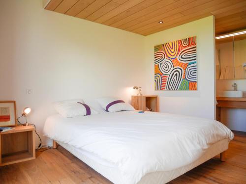 une chambre avec un lit blanc et un tableau au mur dans l'établissement Maison moderne 2019, 3* à 10 mn de la plage de Herlin, 6 pers, jardin, WiFi, inclus : ménage, linge, PdJ - FR-1-418-210, à Bangor