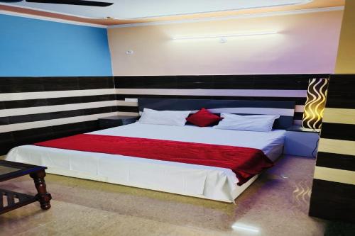 a bedroom with a large bed with a red blanket at OYO Riverview Resort And Restaurant in Jhājhar