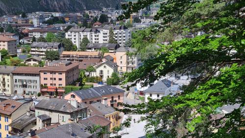 a view of a city with houses and buildings at Chez Pewee, beau duplex en ville, parc privé in Martigny-Ville