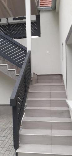 a staircase in a building with a black railing at Apartman for You in Gyenesdiás