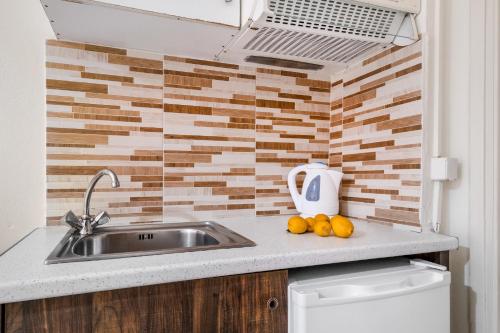 una cocina con fregadero y fruta en una barra en Nikiana Club - Studio 1, en Nikiana