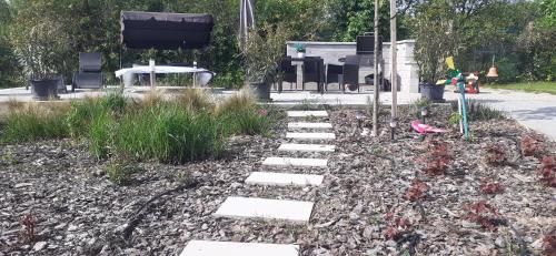 a garden with stepping stones and plants in a yard at Apartman for You in Gyenesdiás