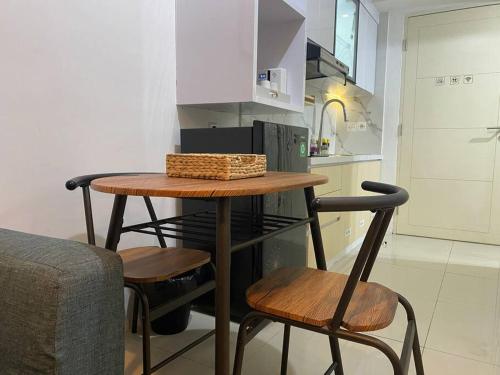 einen kleinen Tisch und zwei Stühle in einer Küche in der Unterkunft Alexa at Tanglin Apartemen in Surabaya