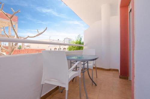 a small balcony with a blue table and a view at Hostal Manolo in Garrucha