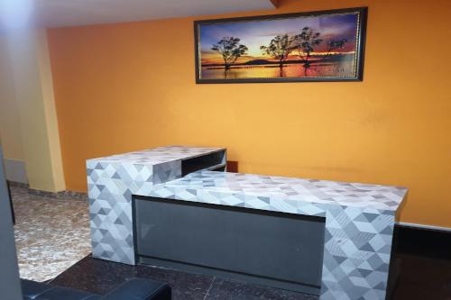einen Tisch in einem Zimmer mit einem Bild an der Wand in der Unterkunft OYO Hotel Eleven in Bhagalpur