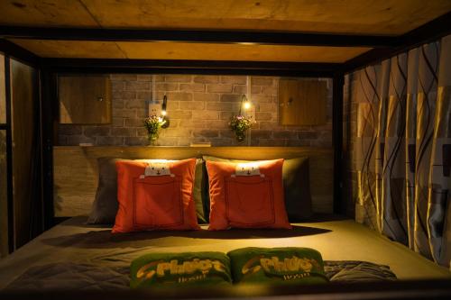 1 cama con almohadas de color naranja y verde en una habitación en Da Nang S Phuot Hostel en Da Nang
