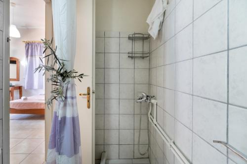 Un baño con ducha con azulejos blancos. en Nikiana Club - Studio 2, en Nikiana