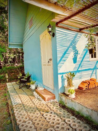 a blue house with a white door and a patio at Pai Casita in Pai