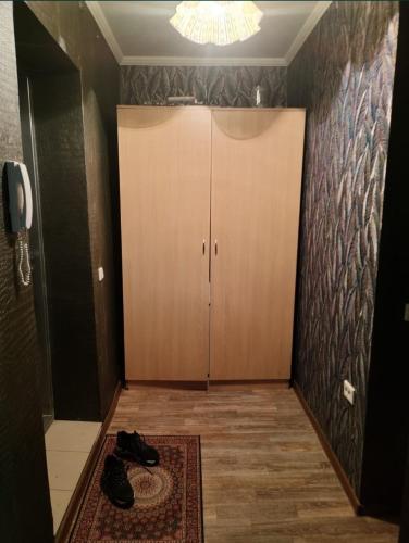 a hallway with a closet and shoes on the floor at Glinki 33 Apartments in Semey