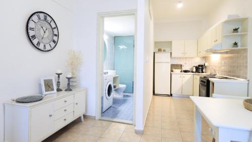 kuchnia z białymi szafkami i zegarem na ścianie w obiekcie Comfortable Apartment with Garden - Casa con Vista w mieście Chavania