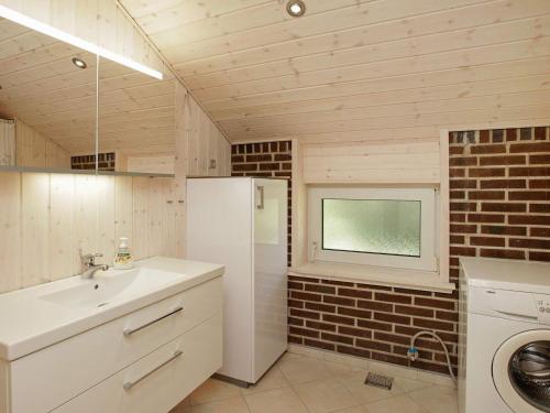 uma cozinha com um lavatório e um frigorífico em Three-Bedroom Holiday home in Blåvand 16 em Ho