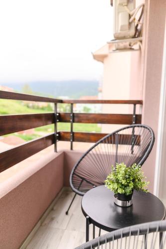 a table and chairs on a balcony with a window at Apartmani ZAT in Soko Banja