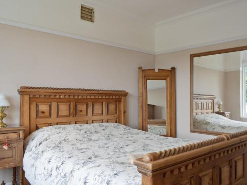 um quarto com uma cama de madeira e um espelho em Bella Vista em Ryde
