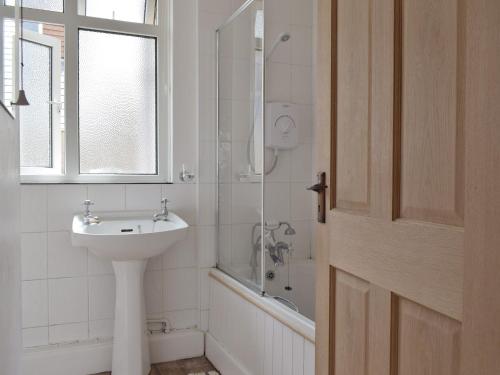 a white bathroom with a sink and a shower at Bella Vista in Ryde