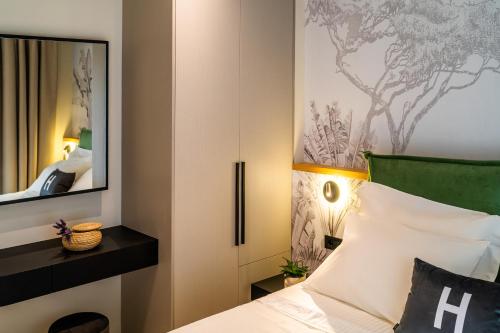 a bedroom with a bed and a mirror at Hara Suites in Parga