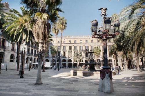 a street light in front of a building with palm trees at Onix Liceo in Barcelona