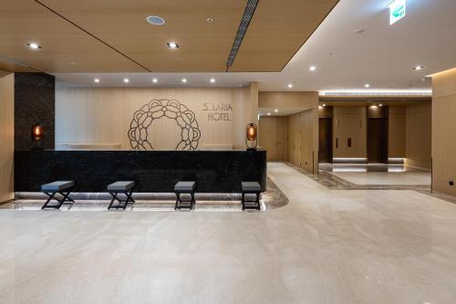 a lobby with a waiting room with chairs and a counter at Solaria Nishitetsu Hotel Taipei Ximen in Taipei