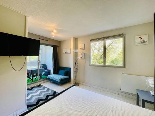 une chambre avec un lit, une télévision et une chaise dans l'établissement Studio rénové pour 2 pers, Centre Port, proche plage, parking inclus - Cap d'Agde - FR-1-723-13, au Cap d'Agde