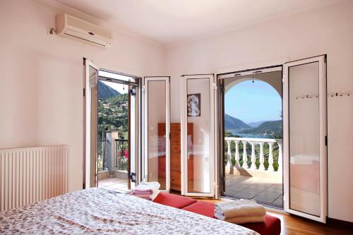 a bedroom with a bed and a view of a balcony at Villa Victoria - 3 Bedroom Villa With a Private Pool in Katokhórion