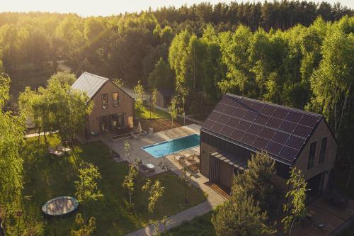an overhead view of a house with solar panels on the roof at Między Brzozami / Domy w lesie in Ciekocino