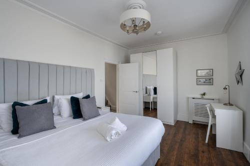 a bedroom with a large white bed with blue pillows at Sea View 4 Bedroom Property in Mumbles in The Mumbles