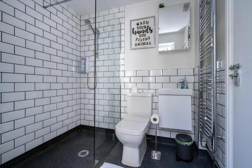 a white bathroom with a toilet and a mirror at Sea View 4 Bedroom Property in Mumbles in The Mumbles