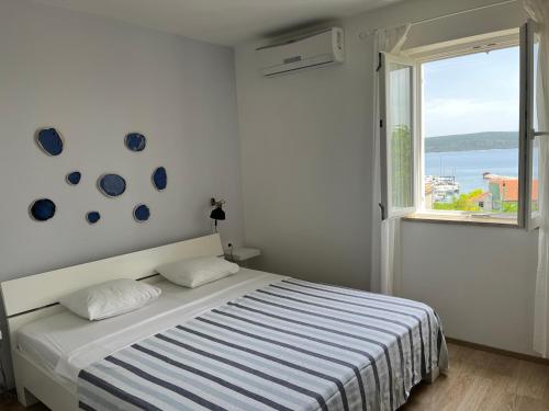 biała sypialnia z łóżkiem i oknem w obiekcie Vita natura Lošinj w miejscowości Mali Lošinj