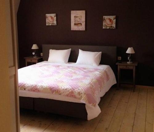 a bedroom with a large bed with two tables at B&B Le Notaire in Bomal