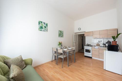 a kitchen and living room with a table and a couch at Prague - Karlin Apartments in Prague