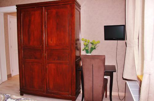 a large wooden cabinet next to a table with a television at B&B Le Notaire in Bomal