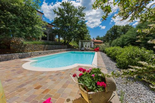 a swimming pool with flowers in a yard at 9b-The Tiny House in Sežana
