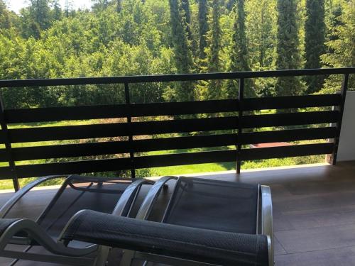 a bench on a balcony with a view of trees at Von der Felsen in Prien am Chiemsee