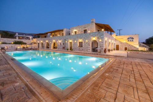 a large swimming pool in front of a building at Avgerinos Village in Agiassos