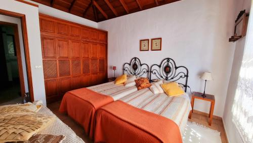 1 dormitorio con 1 cama con manta naranja en Rincón de Mercedes, en Fuencaliente de la Palma