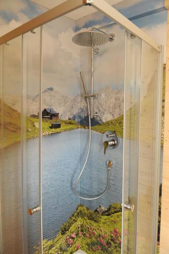 a bathroom with a shower with a painting of a lake at Ferienhof Holzmeister in Sankt Jakob in Haus
