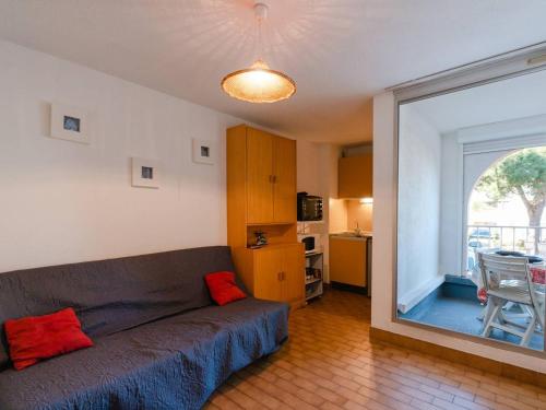 un salon avec un canapé et une grande fenêtre dans l'établissement T2 avec Piscine à Gruissan - Proche Plage et Commerces - FR-1-409A-14, à Gruissan