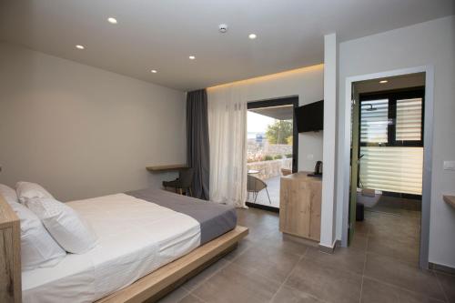 a bedroom with a large bed and a balcony at DeLight Luxury Rooms in Faliraki