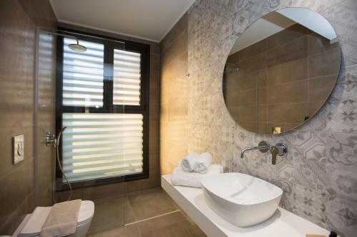 bagno con lavandino e specchio di DeLight Luxury Rooms a Faliraki