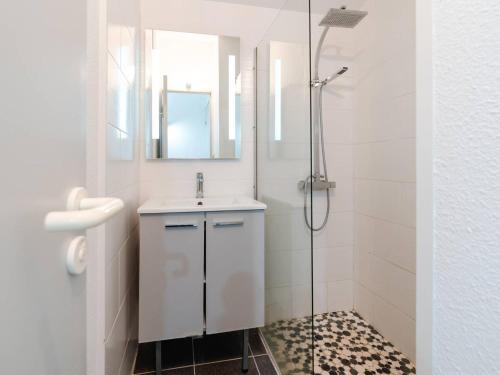 une salle de bain blanche avec un lavabo et une douche dans l'établissement Chaleureuse Villa à Gruissan - 6 pers, Près de la Plage, Garage, Cuisine Équipée, Confort Moderne - FR-1-409A-17, à Gruissan