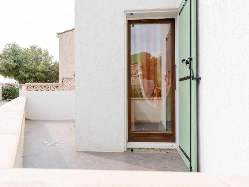 une porte menant à un bâtiment avec une fenêtre dans l'établissement Chaleureuse Villa à Gruissan - 6 pers, Près de la Plage, Garage, Cuisine Équipée, Confort Moderne - FR-1-409A-17, à Gruissan